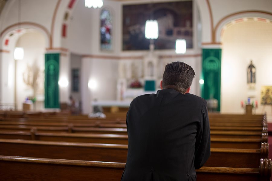 Photo of man praying in a Catholic Church