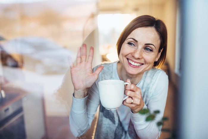 Young business owner waving goodbye after selling her business