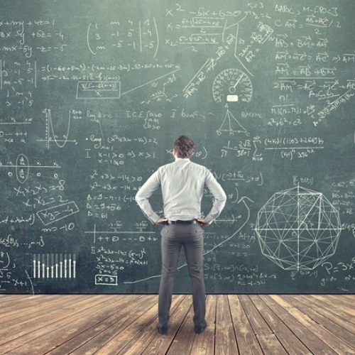 A man looking at a complex diagram on a chalkboard